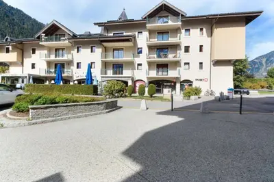 a large building with a parking lot in front of it at Albertine - Centre de Chamonix - Garage - Mountain Views! in Chamonix-Mont-Blanc