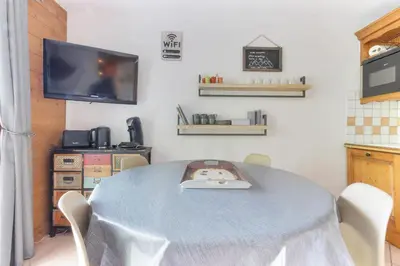a dining room with a table with chairs and a tv at Albertine - Centre de Chamonix - Garage - Mountain Views! in Chamonix-Mont-Blanc