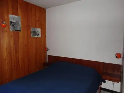 a bedroom with a blue bed and wooden walls at 3P 6 Pers, Cuisine rénovée, Balcon Sud, Proche Pistes et Commerces, Parking, Casier à skis - FR-1-572-204 in Arâches-la-Frasse