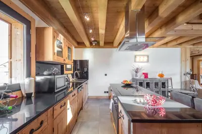 a kitchen with wooden cabinets and a counter top at L'écrin des Bossons in Chamonix-Mont-Blanc
