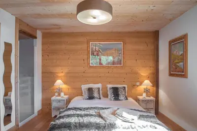 a bedroom with a bed and two night stands with lamps at L'écrin des Bossons in Chamonix-Mont-Blanc