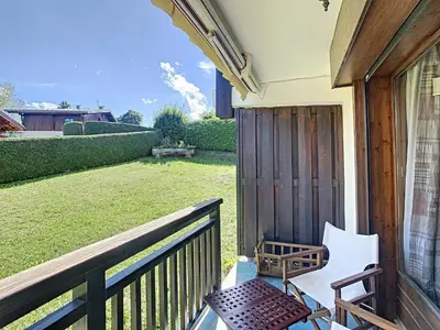 a porch with a chair and a lawn at Charmant 2P à Combloux avec terrasse, parking et casier à ski - FR-1-560-101 in Combloux