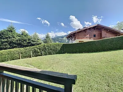 a wooden bench sitting in front of a house at Charmant 2P à Combloux avec terrasse, parking et casier à ski - FR-1-560-101 in Combloux