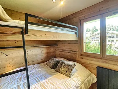 a bedroom with bunk beds in a log cabin at Charmant 2P à Combloux avec terrasse, parking et casier à ski - FR-1-560-101 in Combloux