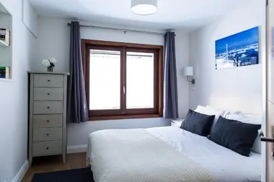 a bedroom with a white bed and a window at Chalet Chintalaya in Chamonix-Mont-Blanc