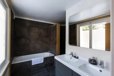a bathroom with a sink and a tub and a mirror at Chalet Chintalaya in Chamonix-Mont-Blanc
