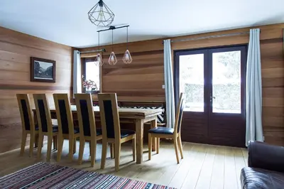 a dining room with a wooden table and chairs at Chalet Chintalaya in Chamonix-Mont-Blanc