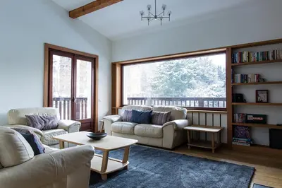 a living room with two couches and a large window at Chalet Chintalaya in Chamonix-Mont-Blanc
