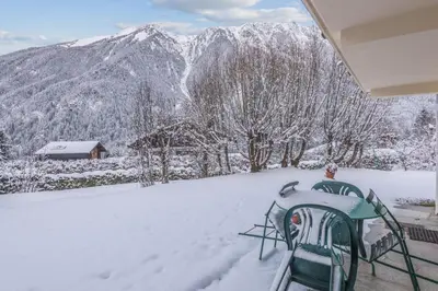 a view of a snow covered mountain from a porch at Chalet Bossons - Welkeys in Chamonix-Mont-Blanc