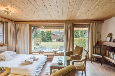 a living room with a bed and a large window at Appartement Lanura - Welkeys in Megève