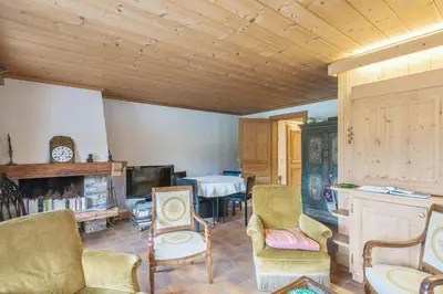 a living room with chairs and a tv and a table at Appartement Lanura - Welkeys in Megève