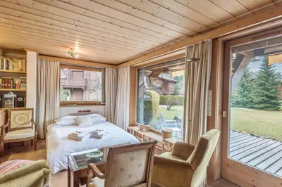 a bedroom with a bed and a large window at Appartement Lanura - Welkeys in Megève