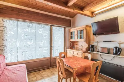 a kitchen with a wooden table and a large window at Appartement Warens - Welkeys in Megève
