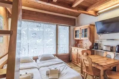 a room with three beds and a table and a window at Appartement Warens - Welkeys in Megève