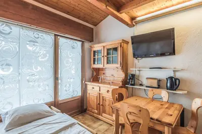 a dining room with a table and a tv at Appartement Warens - Welkeys in Megève