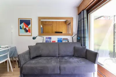a couch in a living room with a window at Beau Glacier - Pied des Pistes - Balcons du Savoy in Chamonix-Mont-Blanc