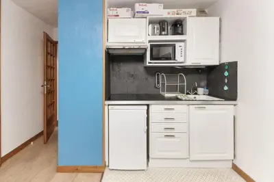 a small kitchen with white cabinets and a microwave at Beau Glacier - Pied des Pistes - Balcons du Savoy in Chamonix-Mont-Blanc
