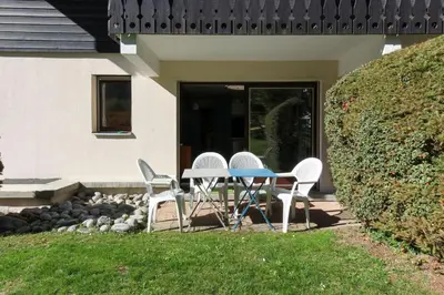 three chairs and a table in front of a house at Beau Glacier - Pied des Pistes - Balcons du Savoy in Chamonix-Mont-Blanc
