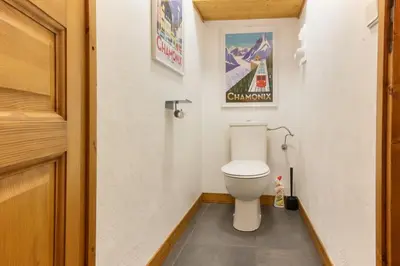 a bathroom with a toilet and a poster on the wall at Beau Glacier - Pied des Pistes - Balcons du Savoy in Chamonix-Mont-Blanc