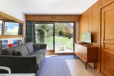 a living room with a couch and a television at Beau Glacier - Pied des Pistes - Balcons du Savoy in Chamonix-Mont-Blanc
