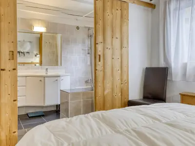 a bedroom with a bed and a chair and a sink at Appartement lumineux 2 chambres proche centre, animaux admis, parking, WiFi - FR-1-453-296 in Megève