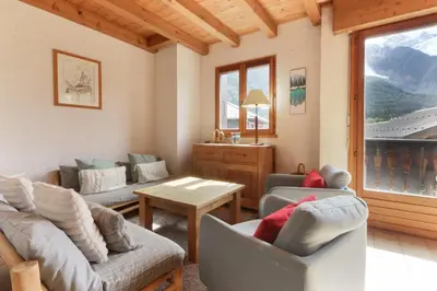 a living room with couches and a table at Le Chamouny- Family Apt - Central - Quiet - Hikeing & Rock Climbing Close by in Chamonix-Mont-Blanc