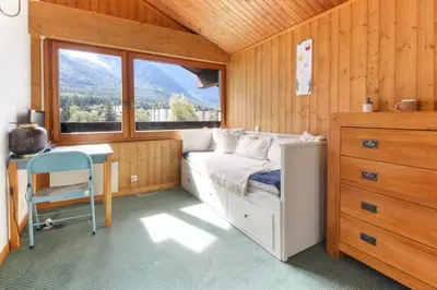 a bedroom with a bed and a desk and a window at Le Chamouny- Family Apt - Central - Quiet - Hikeing & Rock Climbing Close by in Chamonix-Mont-Blanc