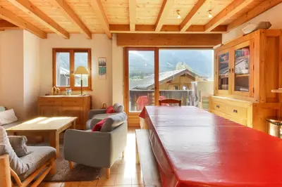 a living room with a large wooden table and chairs at Le Chamouny- Family Apt - Central - Quiet - Hikeing & Rock Climbing Close by in Chamonix-Mont-Blanc