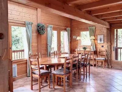 a dining room with a wooden table and chairs at Chalet rénové 3 étoiles, 14 pers, vue Mont Blanc, Wifi - FR-1-560-102 in Cordon