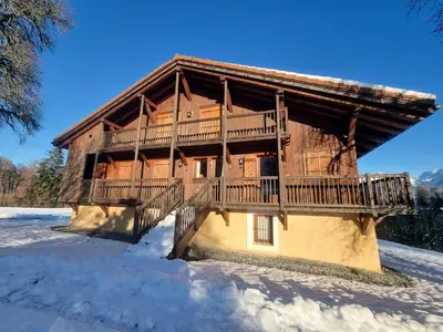 a log cabin with a deck in the snow at Chalet rénové 3 étoiles, 14 pers, vue Mont Blanc, Wifi - FR-1-560-102 in Cordon