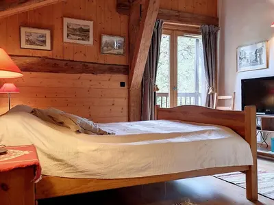 a bedroom with a bed in a room with wooden walls at Chalet rénové 3 étoiles, 14 pers, vue Mont Blanc, Wifi - FR-1-560-102 in Cordon