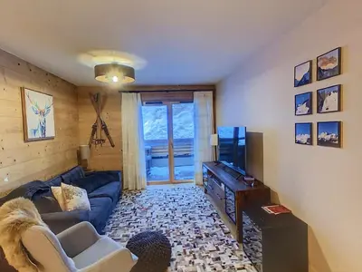 a living room with a couch and a tv at gcf210 in Les Carroz d'Araches