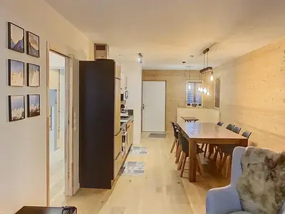 a dining room with a wooden wall with a table and chairs at gcf210 in Les Carroz d'Araches