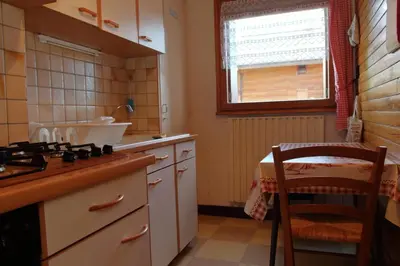 a kitchen with a stove and a table and a window at mlb22 in Les Carroz d'Araches
