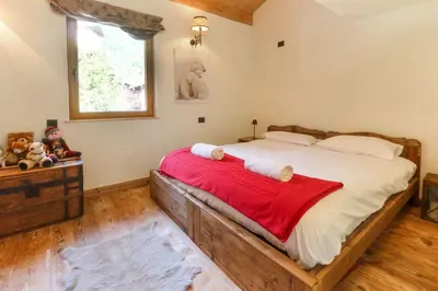 a bedroom with a large bed with a red blanket at Clos des Vorgeats - Duplex Beside Golf Course - Patio - UTMB in Chamonix-Mont-Blanc