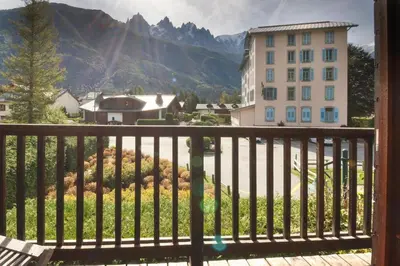 a balcony with a view of a building and mountains at Clos des Vorgeats - Duplex Beside Golf Course - Patio - UTMB in Chamonix-Mont-Blanc