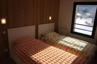 a bedroom with two beds and a window at Modern 2BR 5* pool gym spa garage Mont-Blanc view in Chamonix-Mont-Blanc