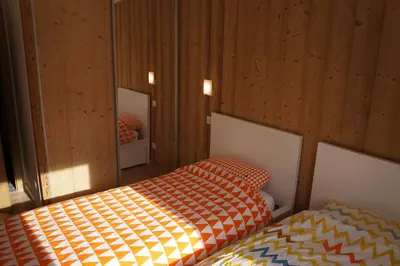 a bedroom with two beds and two mirrors at Modern 2BR 5* pool gym spa garage Mont-Blanc view in Chamonix-Mont-Blanc