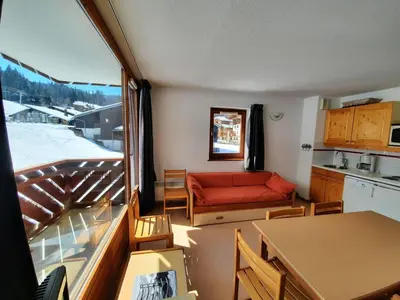 a living room with a red couch and a kitchen at 3 Pièces au pied des pistes - Morillon 1100, 6-7 pers, TV - FR-1-815-89 in Morillon