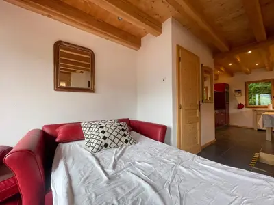 a bedroom with a bed with a red couch at Chalet tradition 6 pers avec cheminée, balcon et parking à Samoëns - FR-1-624-124 in Samoëns