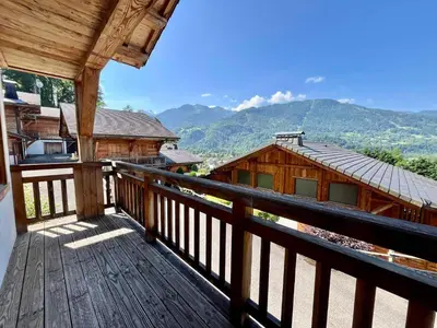 a wooden balcony with a view of a house at Chalet tradition 6 pers avec cheminée, balcon et parking à Samoëns - FR-1-624-124 in Samoëns