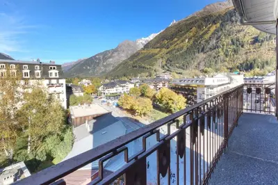 a balcony with a view of a town and mountains at Carlton - Center of Chamonix - Historic building in Chamonix-Mont-Blanc