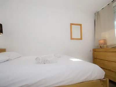 a bedroom with a white bed and a wooden dresser at Appartement cosy à Chamonix Sud pour 4 pers, animaux acceptés - FR-1-343-157 in Chamonix-Mont-Blanc