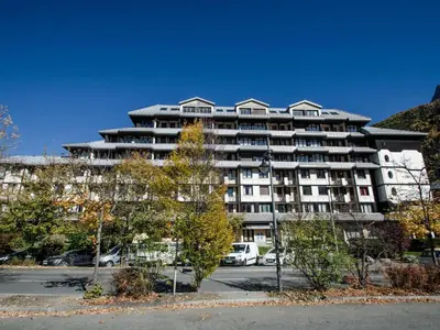 a large building with cars parked in front of it at Appartement cosy à Chamonix Sud pour 4 pers, animaux acceptés - FR-1-343-157 in Chamonix-Mont-Blanc