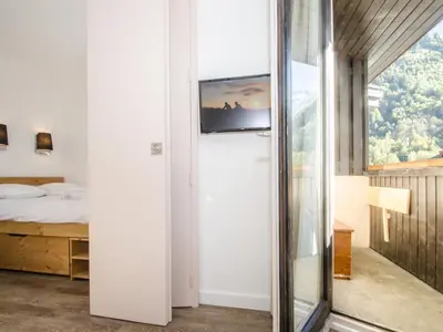 a bedroom with a bed and a sliding glass door at Appartement cosy à Chamonix Sud pour 4 pers, animaux acceptés - FR-1-343-157 in Chamonix-Mont-Blanc