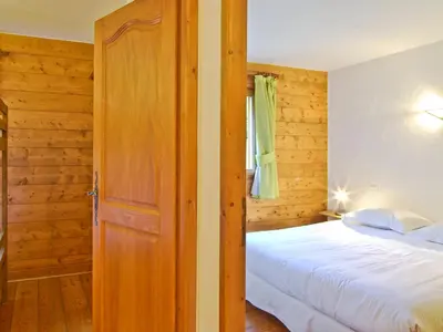 a bedroom with a bed and a wooden door at Appartement 6 pers, Chamonix, Parking - FR-1-343-169 in Chamonix-Mont-Blanc