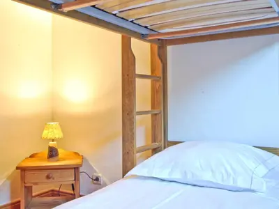 a bed with a wooden bed frame and a lamp on a table at Appartement 6 pers, Chamonix, Parking - FR-1-343-169 in Chamonix-Mont-Blanc