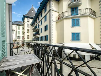 a wooden bench sitting on a balcony with buildings at Bel appartement 3 étoiles avec balcon au cœur de Chamonix - FR-1-343-165 in Chamonix-Mont-Blanc