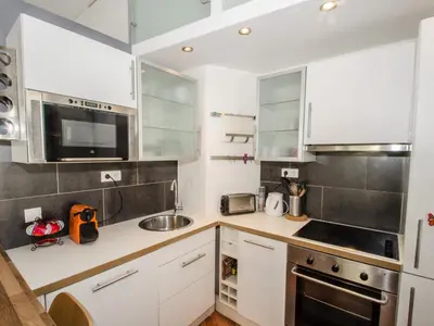 a kitchen with white cabinets and stainless steel appliances at Bel appartement 3 étoiles avec balcon au cœur de Chamonix - FR-1-343-165 in Chamonix-Mont-Blanc