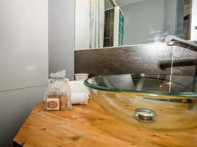 a bathroom with a glass bowl sink on a wooden counter at Bel appartement 3 étoiles avec balcon au cœur de Chamonix - FR-1-343-165 in Chamonix-Mont-Blanc